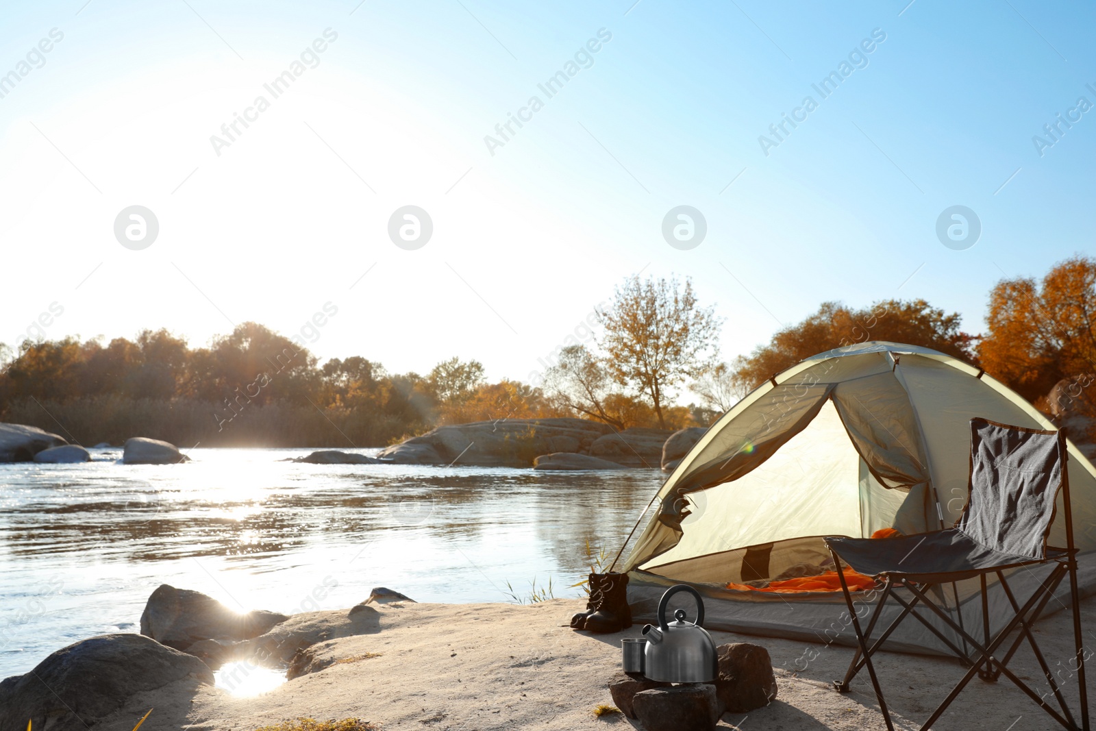 Photo of Camping equipment near tent with sleeping bag outdoors