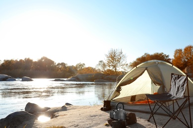 Camping equipment near tent with sleeping bag outdoors