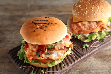 Photo of Tasty burgers with bacon served on table