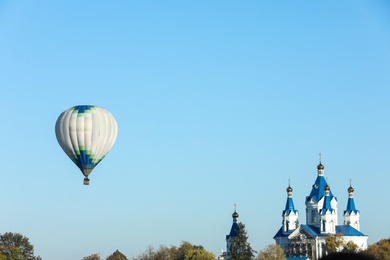 Photo of KAMIANETS-PODILSKYI, UKRAINE - OCTOBER 06, 2018: Beautiful viewhot air balloon flying near Saint George's Cathedral. Space for text