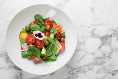 Photo of Delicious salad with vegetables and olives on white marble table, top view. Space for text
