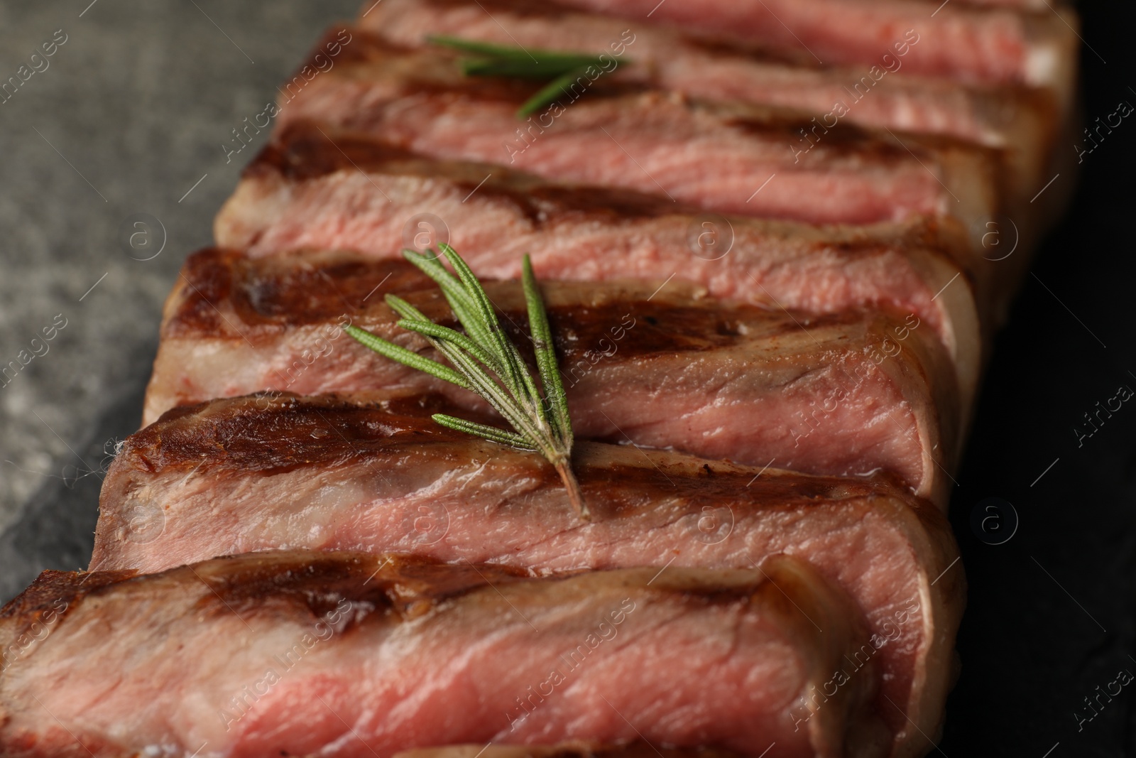 Photo of Delicious grilled beef steak with rosemary on table, closeup
