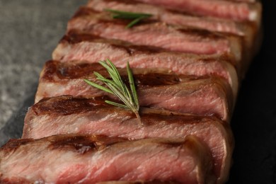 Photo of Delicious grilled beef steak with rosemary on table, closeup