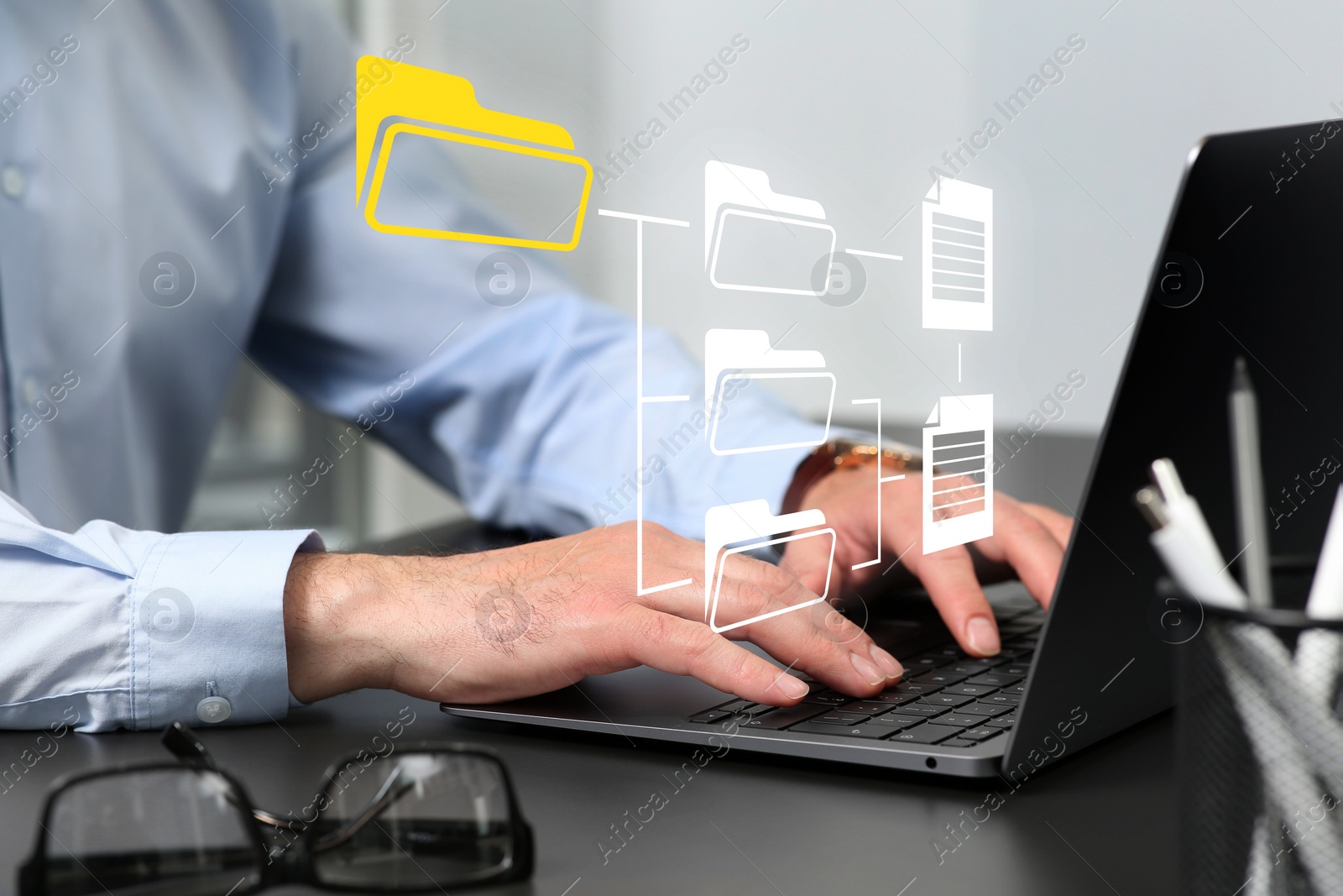 Image of File system. Man using laptop at table, closeup. Scheme with folders and documents over computer