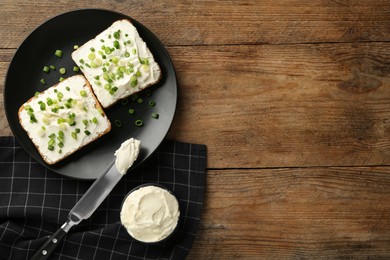 Photo of Delicious sandwiches with cream cheese and chives on wooden table, flat lay. Space for text