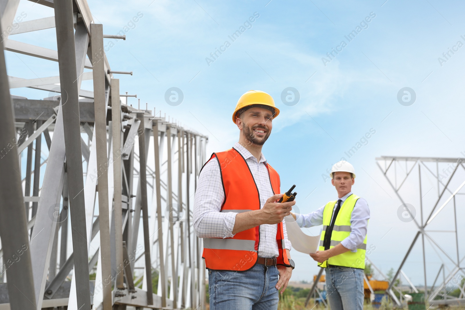 Photo of Professional engineers working on installation of electrical substation outdoors