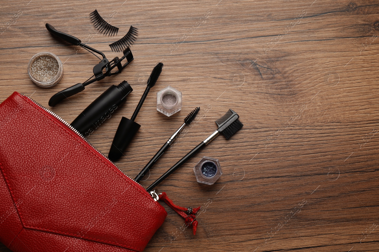 Photo of Flat lay composition with eyelash curler, makeup products and accessories on wooden table. Space for text