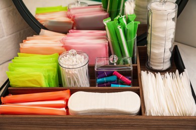 Photo of Wooden organizer with different feminine hygiene products on table, closeup