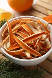 Photo of Dry orange peels, oranges and fir branch on white table, closeup