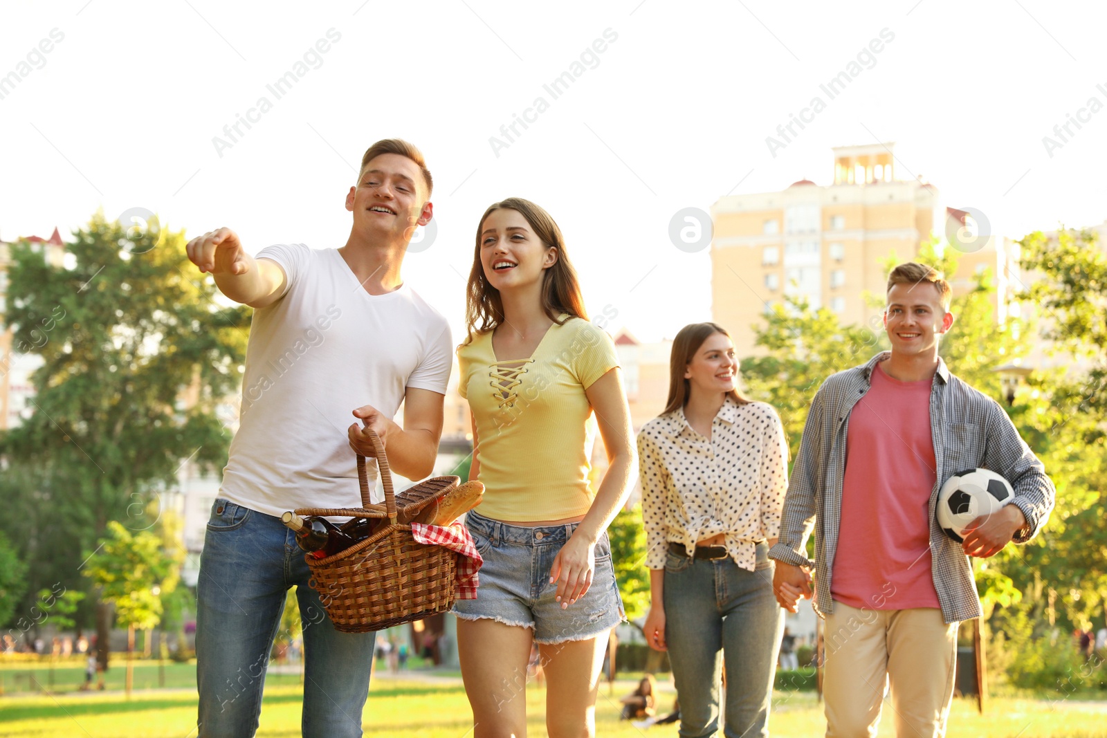 Photo of Young people with picnic basket in park on summer day