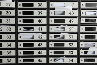 Photo of Metal mailboxes with keyholes, numbers and receipts as background