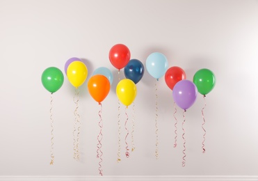 Different bright balloons on light background. Celebration time