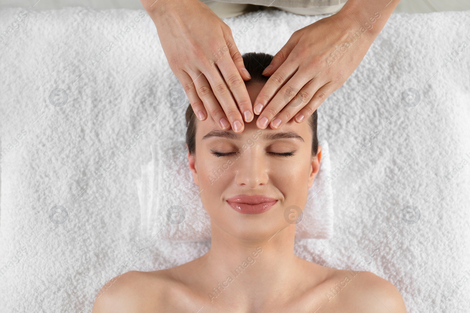 Photo of Beautiful young woman enjoying massage in spa salon, top view