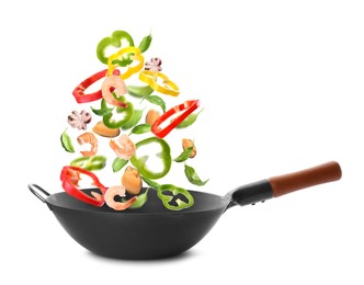 Image of Different tasty ingredients falling into wok on white background