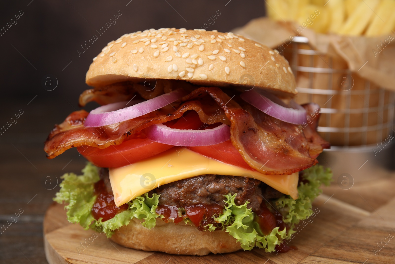 Photo of Tasty burger with bacon, vegetables and patty on wooden table, closeup