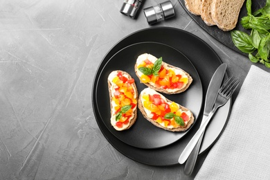 Tasty fresh tomato bruschettas on grey table, flat lay. Space for text