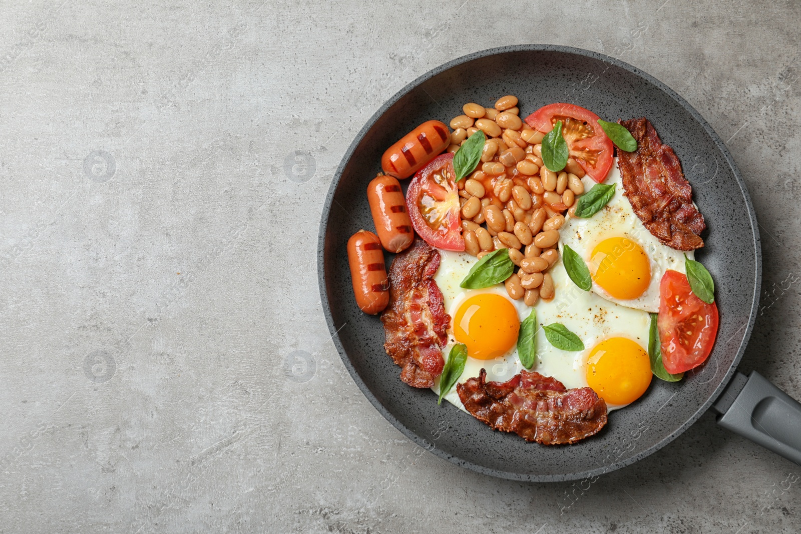 Photo of Delicious breakfast with fried eggs served on grey table, top view. Space for text