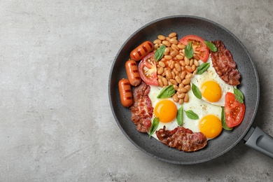 Photo of Delicious breakfast with fried eggs served on grey table, top view. Space for text