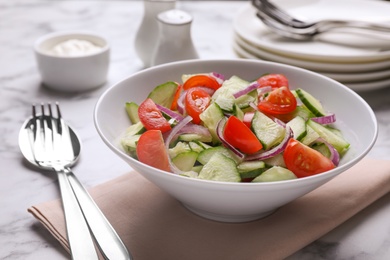 Photo of Delicious fresh cucumber tomato salad served on table