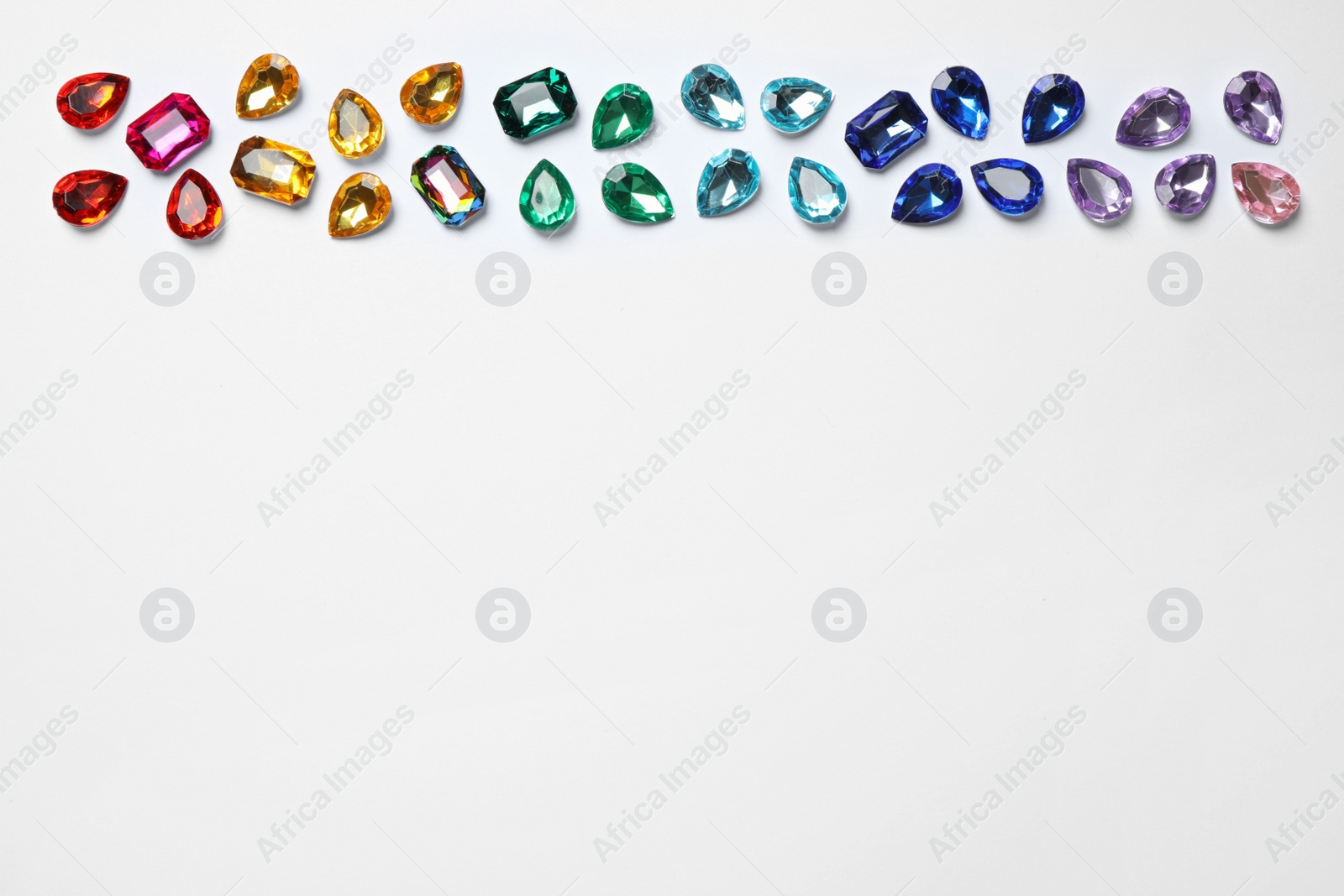 Photo of Different beautiful gemstones on white background, top view