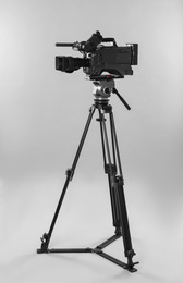 Modern professional video camera on light background