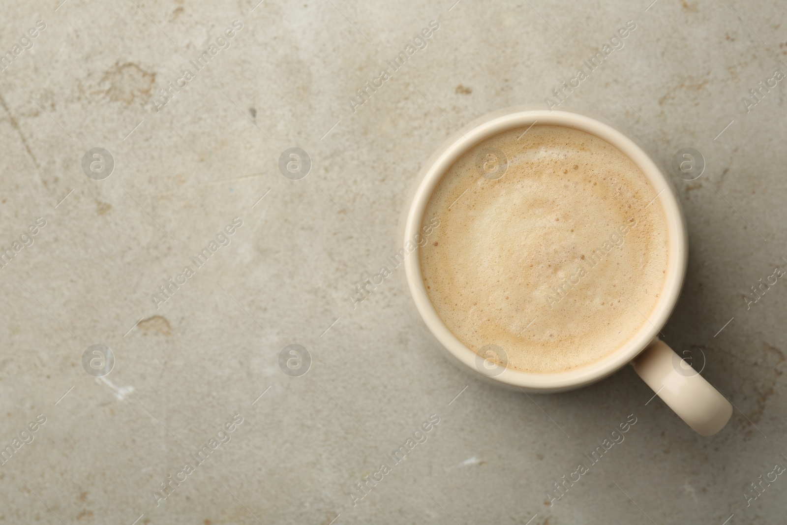 Photo of Cup of coffee on grey table, top view. Space for text