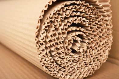 Photo of Roll of brown corrugated cardboard, closeup. Recyclable material