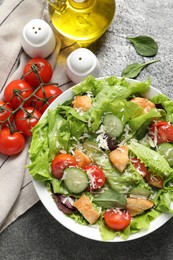 Delicious salad with chicken, cheese and vegetables served on grey table, flat lay