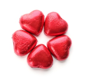 Heart shaped chocolate candies in red foil on white background, top view