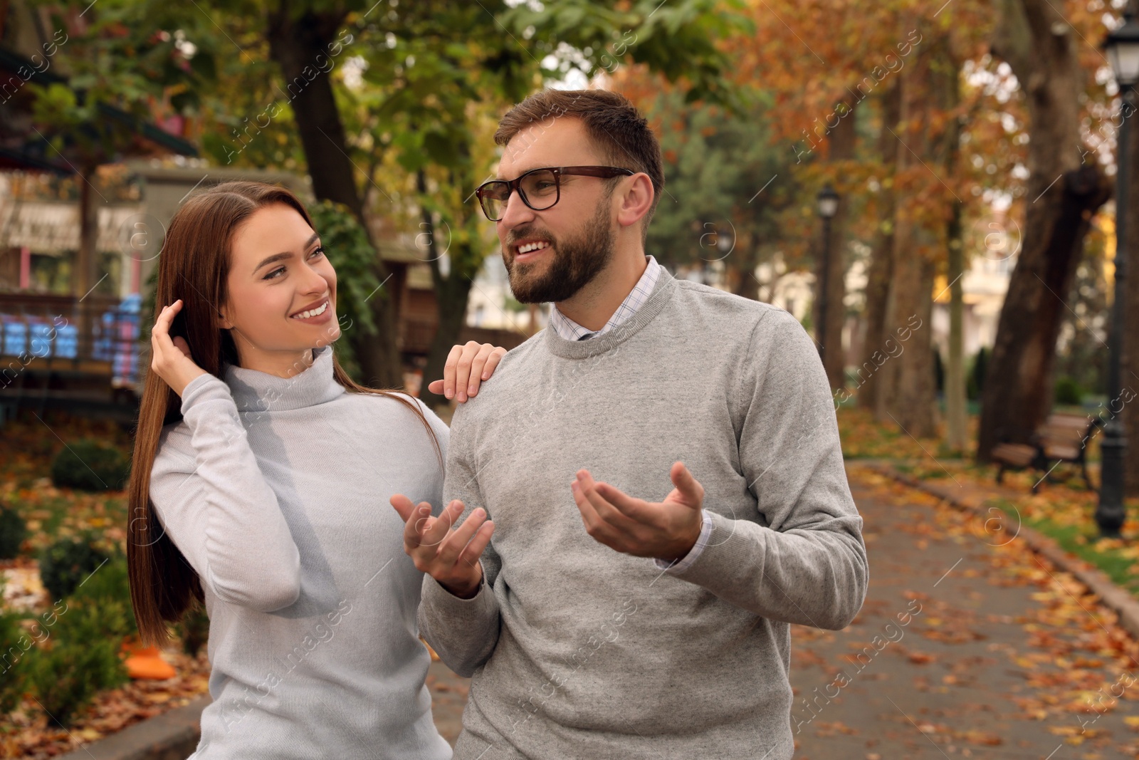 Photo of Happy couple wearing stylish clothes in autumn park