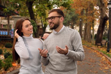 Photo of Happy couple wearing stylish clothes in autumn park