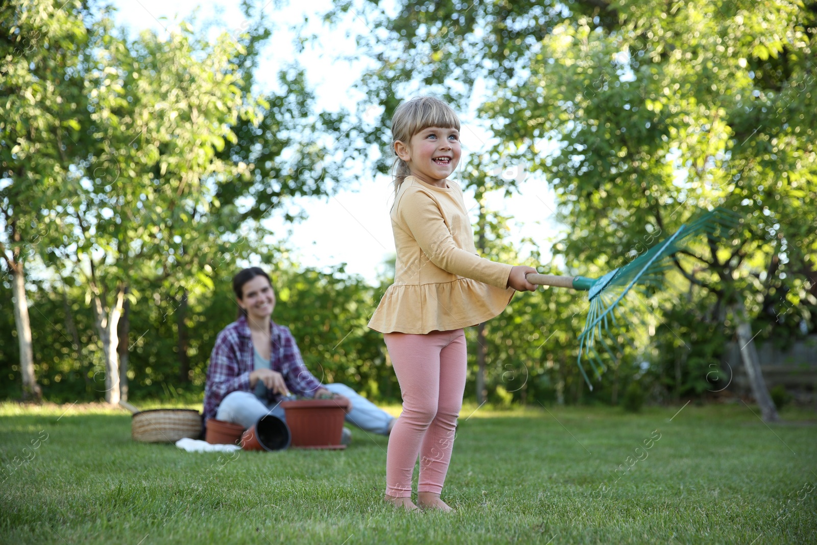 Photo of Mother and her daughter working together in garden