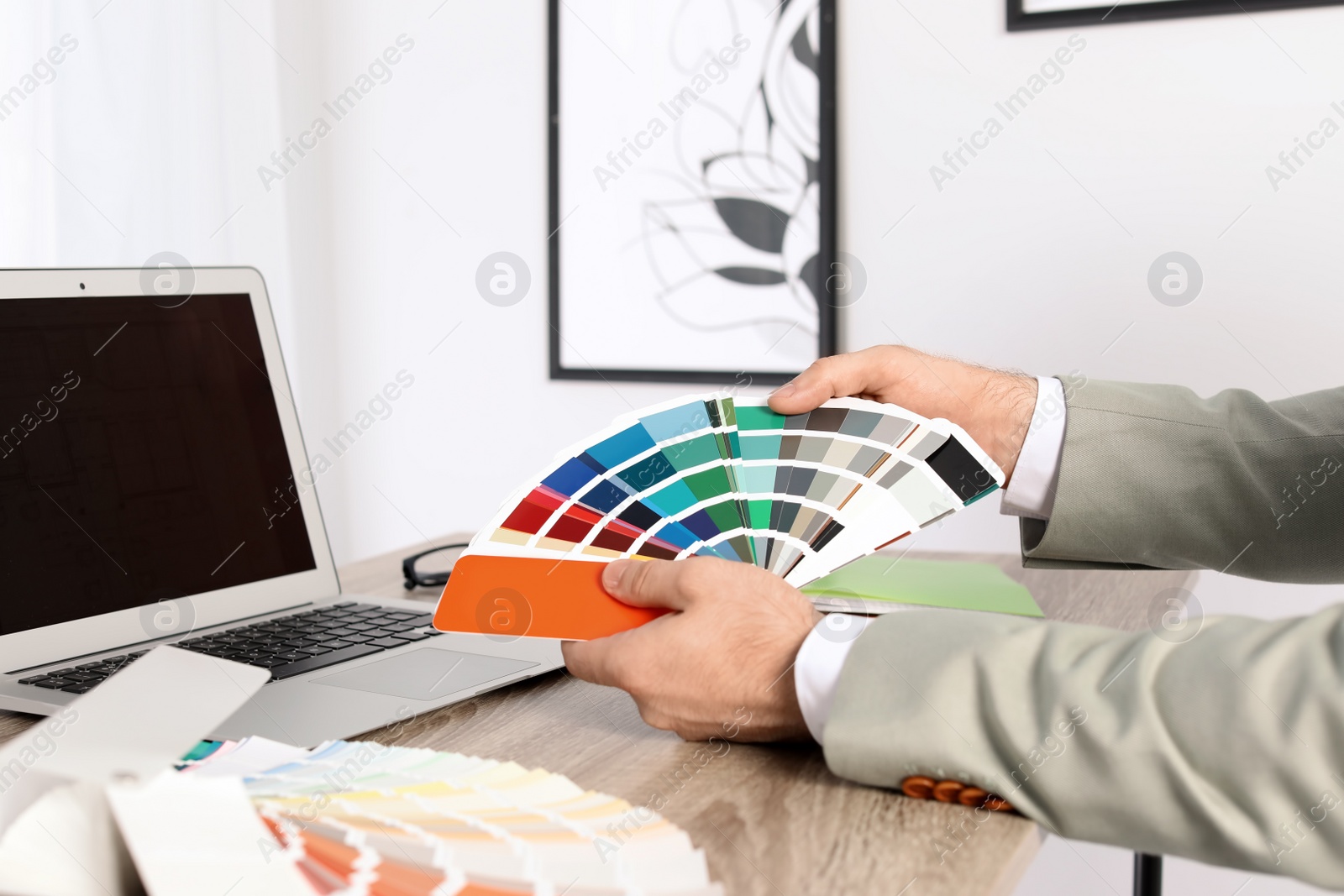 Photo of Male designer working with color palette at office table, closeup