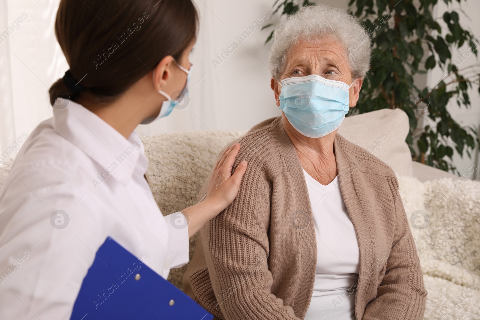 Photo of Doctor taking care of senior woman with protective mask at nursing home