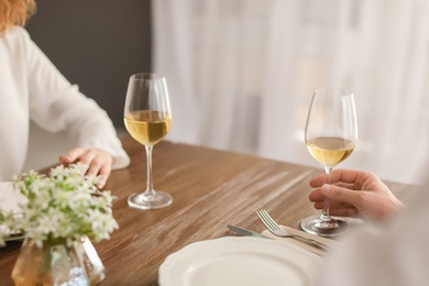 Photo of Young couple with glasses of delicious wine in restaurant