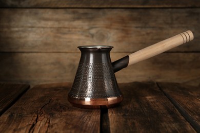 Photo of Copper turkish coffee pot on wooden table