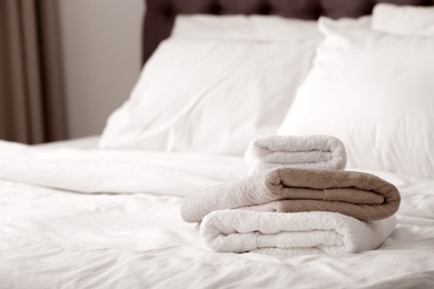 Photo of Stack of clean towels on bed