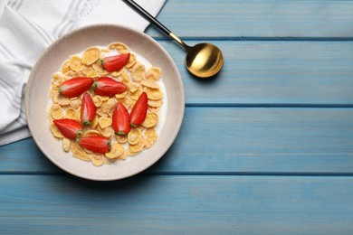 Photo of Delicious crispy cornflakes with milk and fresh strawberries on light blue wooden table, flat lay. Space for text