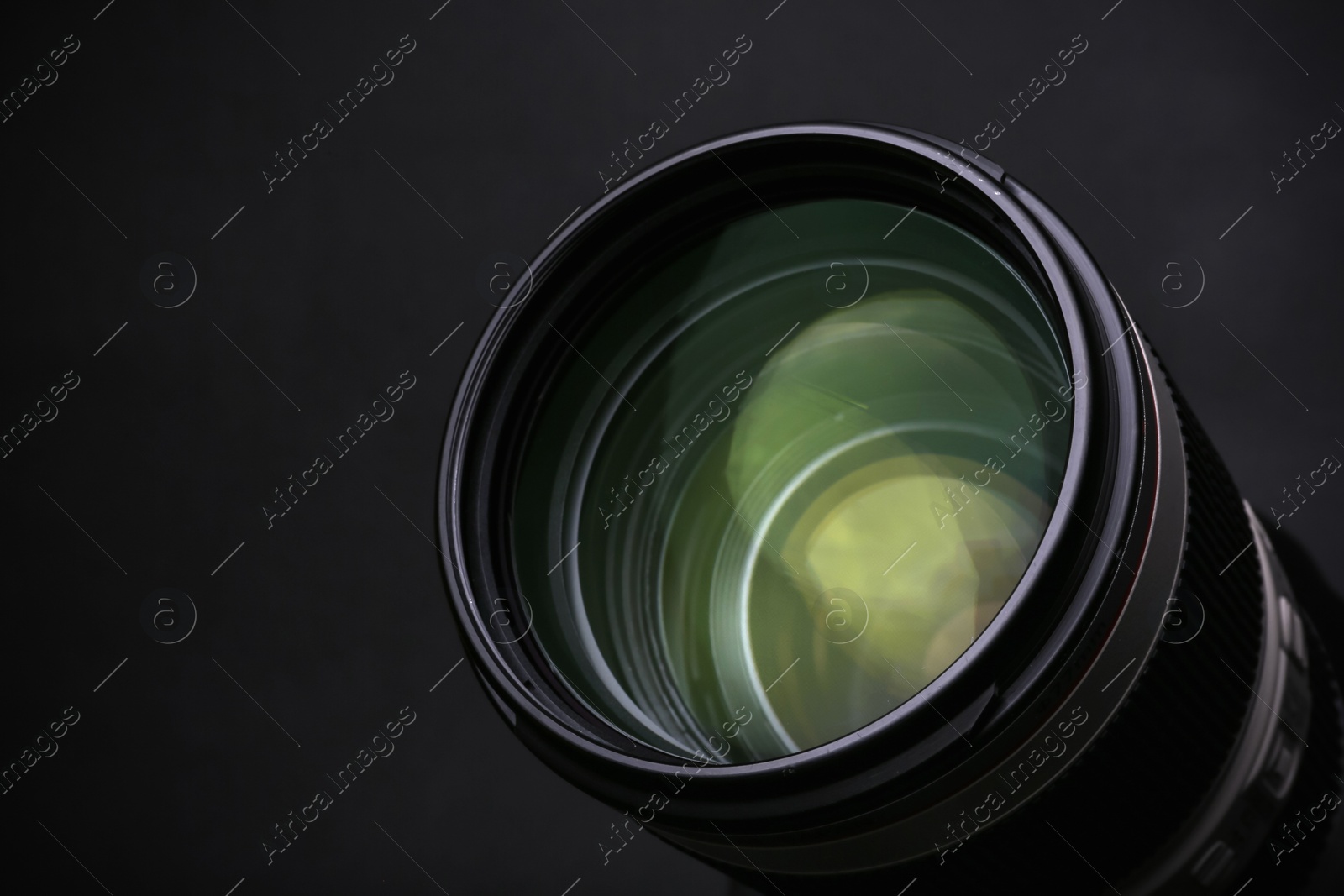 Photo of Modern camera lens on black background, closeup. Space for text