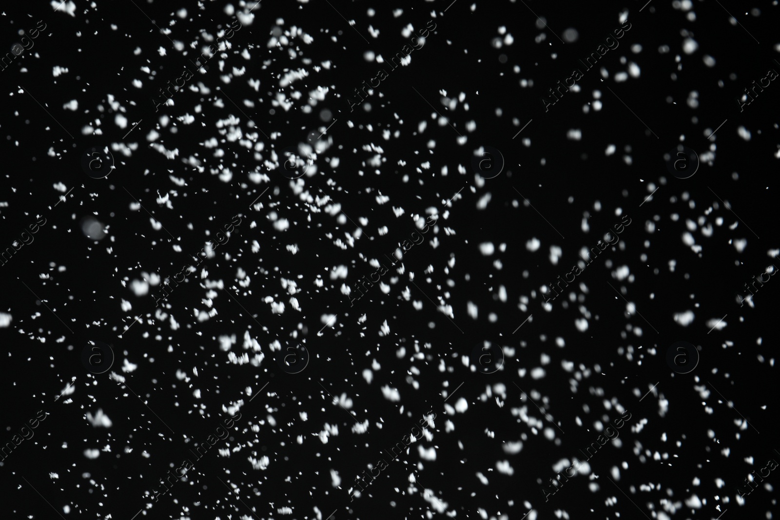 Photo of White snow falling down on black background