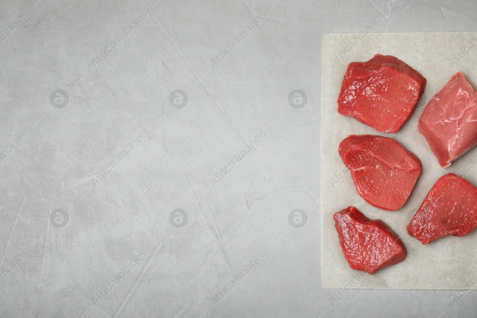 Photo of Flat lay composition with fresh raw meat and space for text on gray background