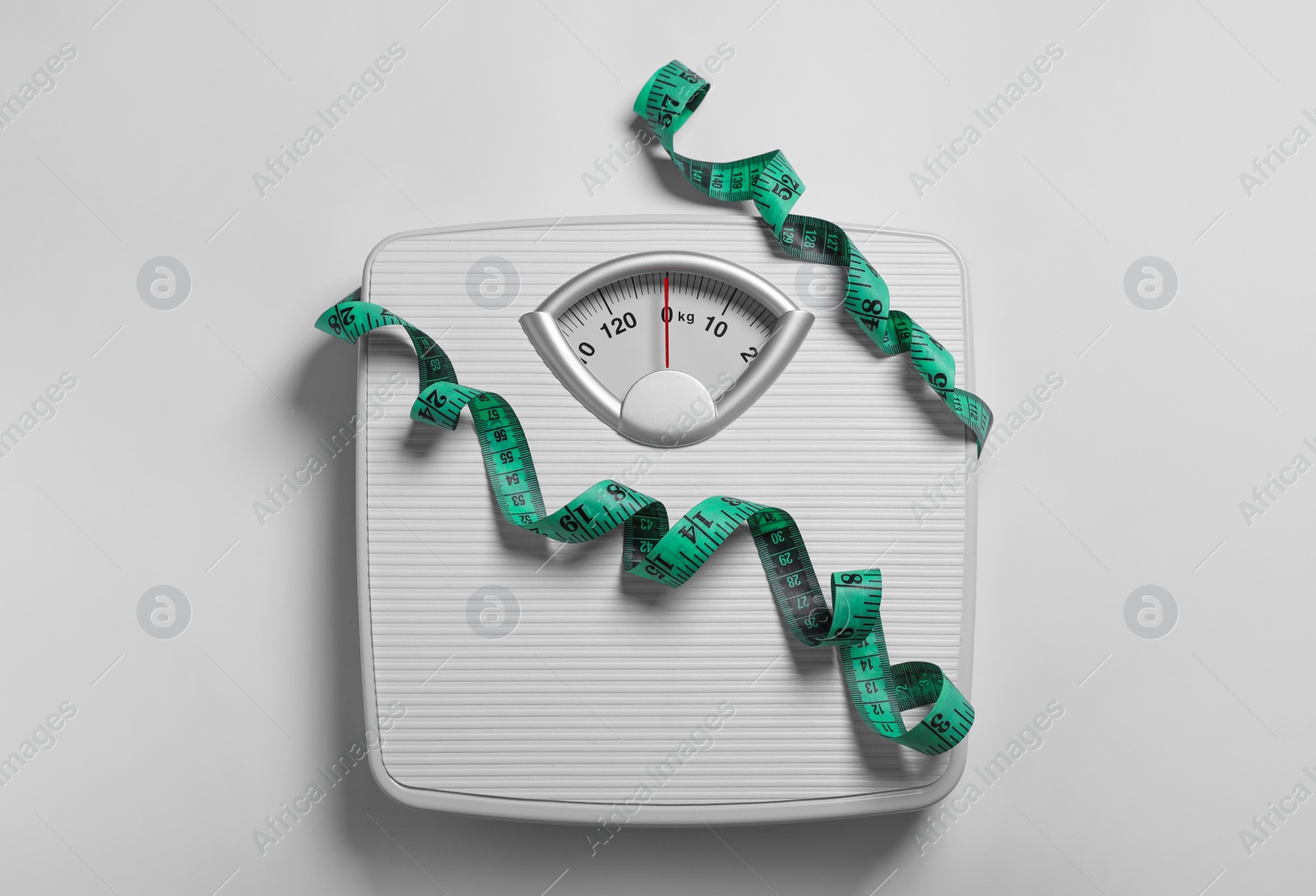 Photo of Weight loss concept. Scales and measuring tape on white background, top view