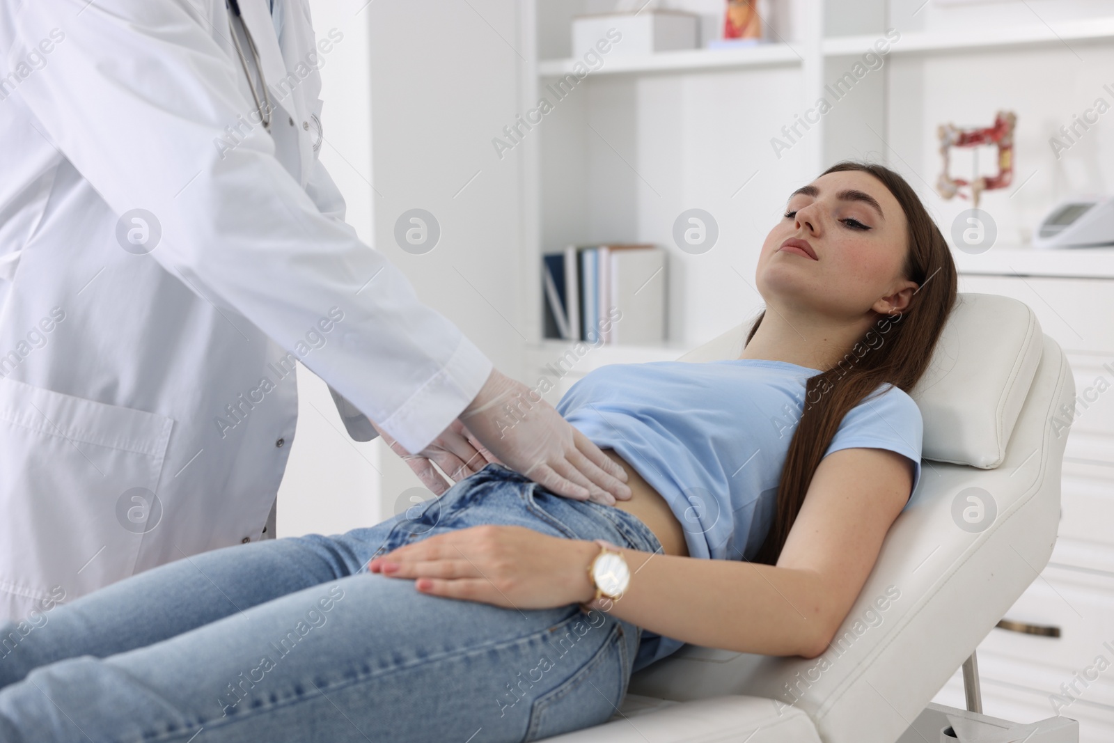 Photo of Gastroenterologist examining patient with stomach pain on couch in clinic, closeup