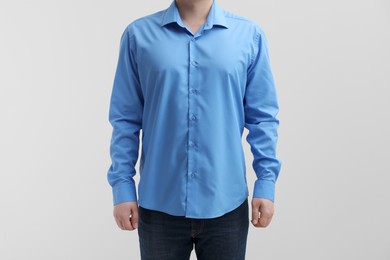 Man wearing clean shirt on white background, closeup. Space for text