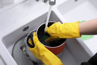 Woman washing dirty dishes in kitchen sink, closeup