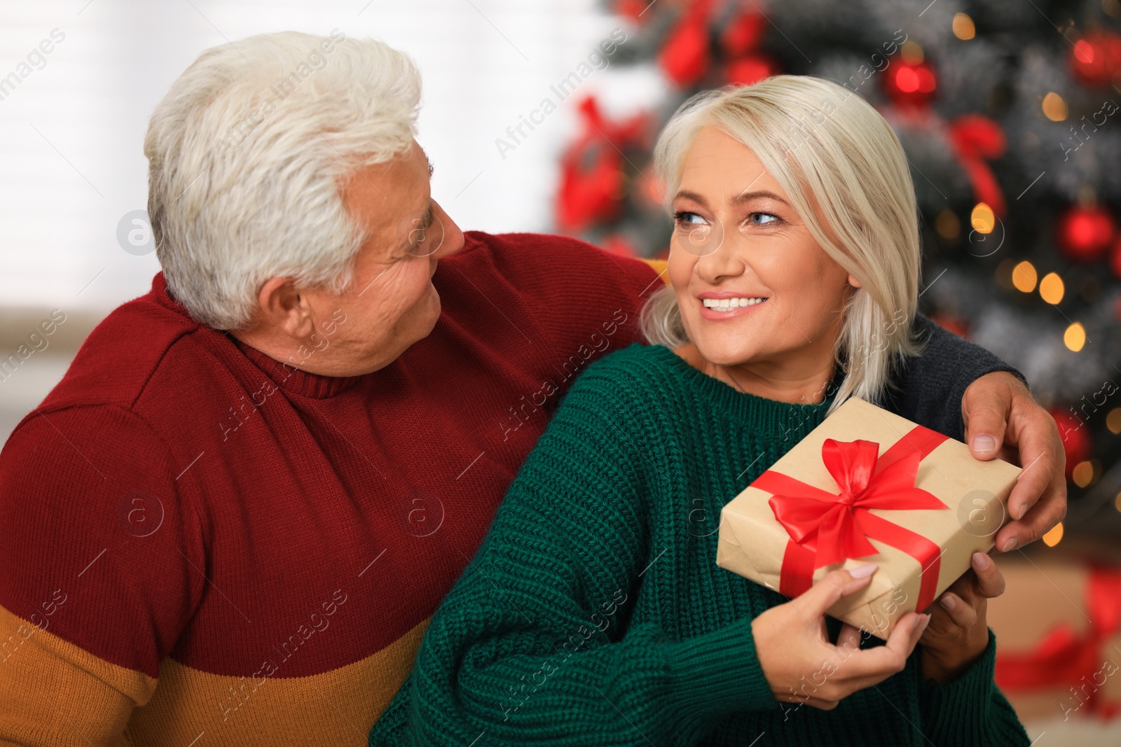 Photo of Happy mature couple with Christmas gift at home