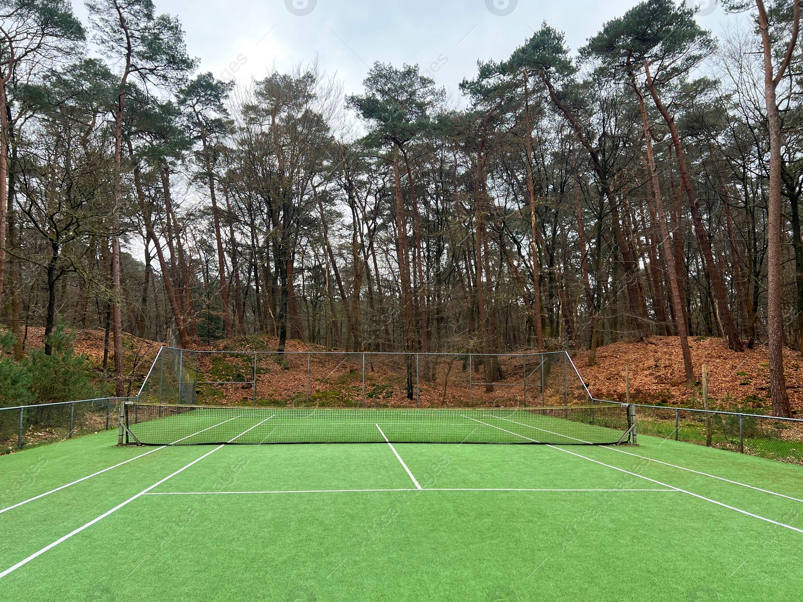 Photo of Tennis court with artificial grass and net outdoors