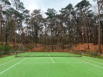 Tennis court with artificial grass and net outdoors