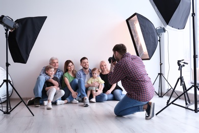 Photo of Professional photographer taking photo of family in studio