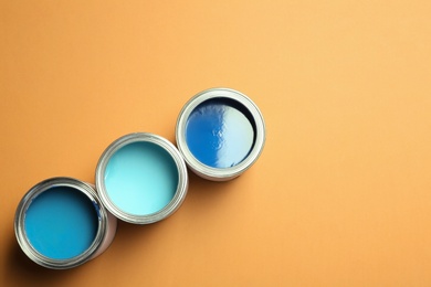 Photo of Flat lay composition with paint cans and space for text on color background